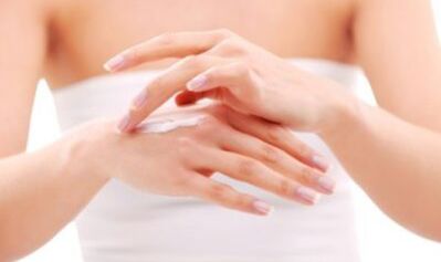 Girl applying ointment on hands